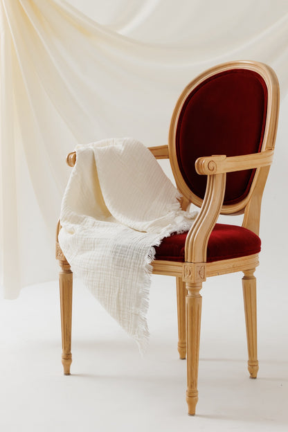 A 4-layer cotton crinkle blanket elegantly placed on a chair.