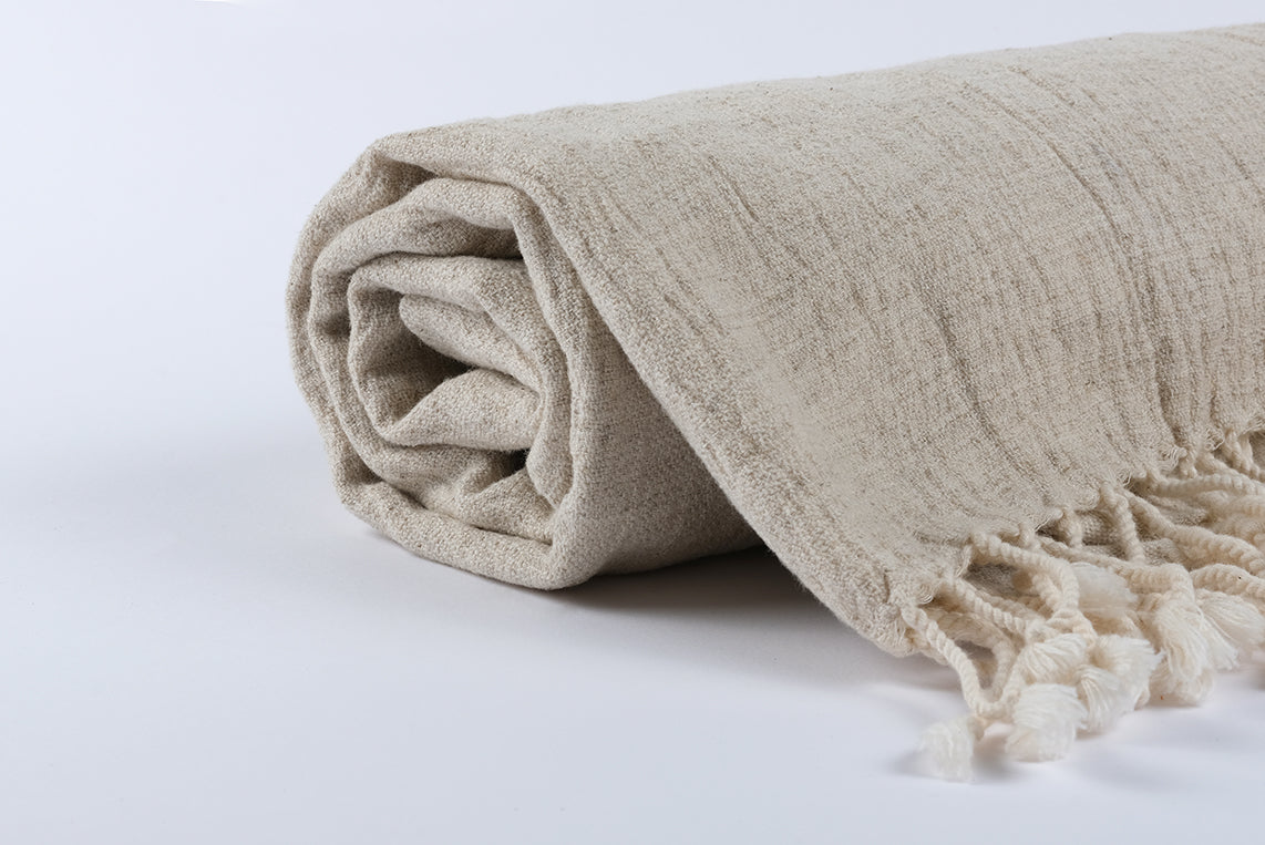 Close-up of naturally crinkled cotton linen peshtemal fabric with soft handwoven texture
