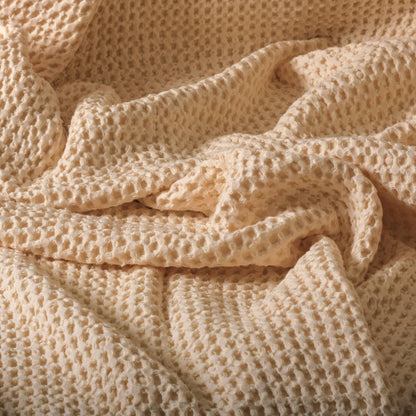 Folded undyed cotton waffle fabric with a lofty honeycomb weave, suitable for natural dyeing and sewing projects