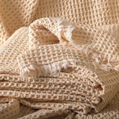 Undyed 100% cotton waffle fabric in natural color, stacked to show the soft honeycomb texture.